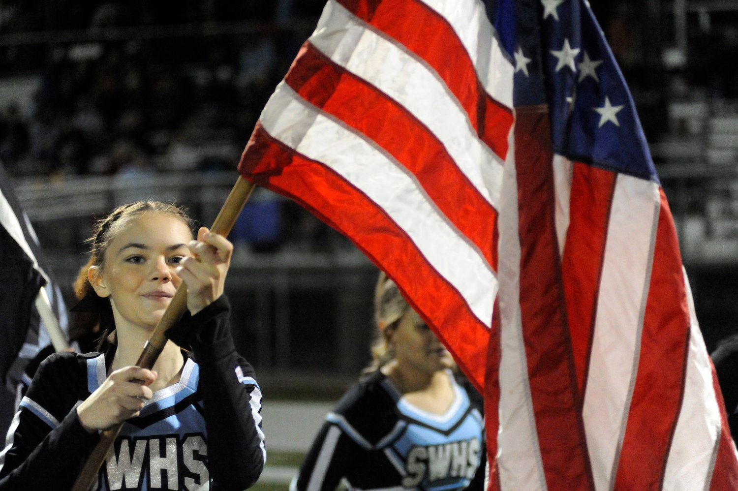 American pride. Sullivan West senior cheerleader Anabella “Bella” Wagner carried Old Glory onto the field before the opening kickoff...